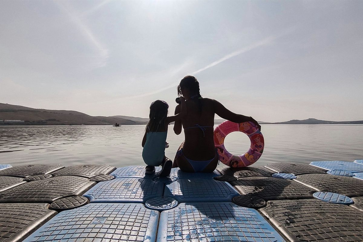 Family swimming from a floating dock on the lake